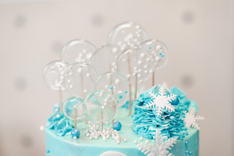 Gâteau bleu givré décoré de flocons de neige, perles sucrées et sucettes cristallines - Gateau Reine Neige